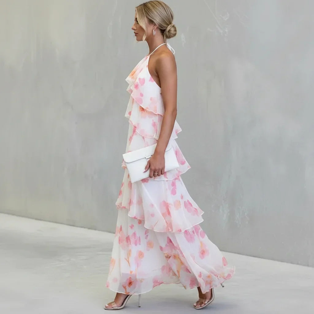 Estrella tiered floral dress in white and pink, walking side view with clutch