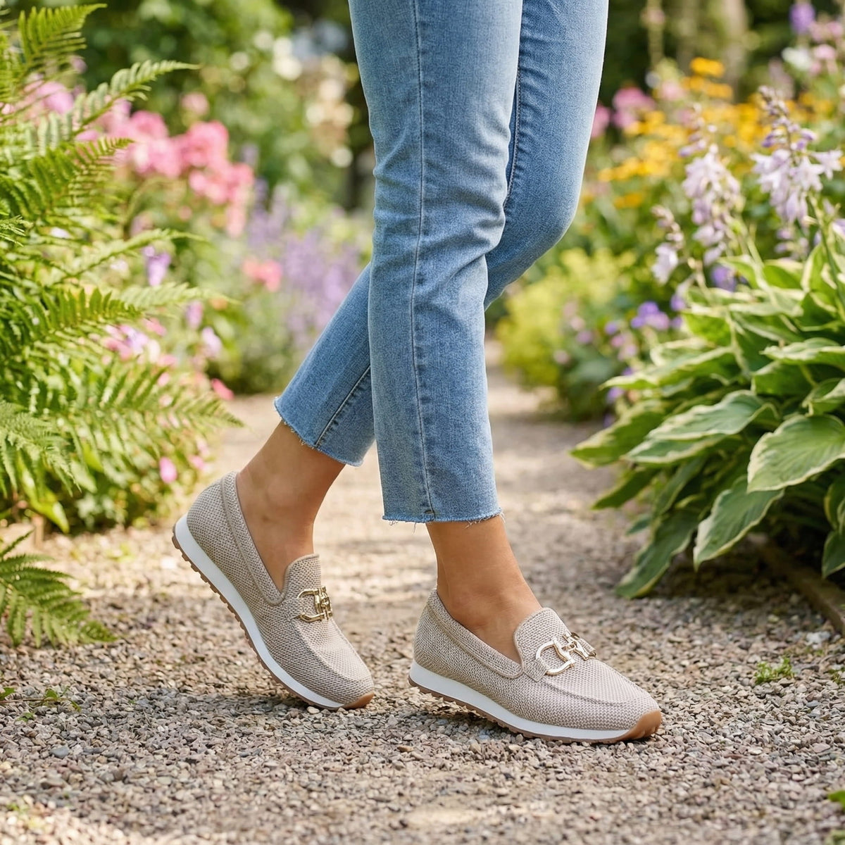 Shiloh beige loafer trainers worn on a garden path with jeans