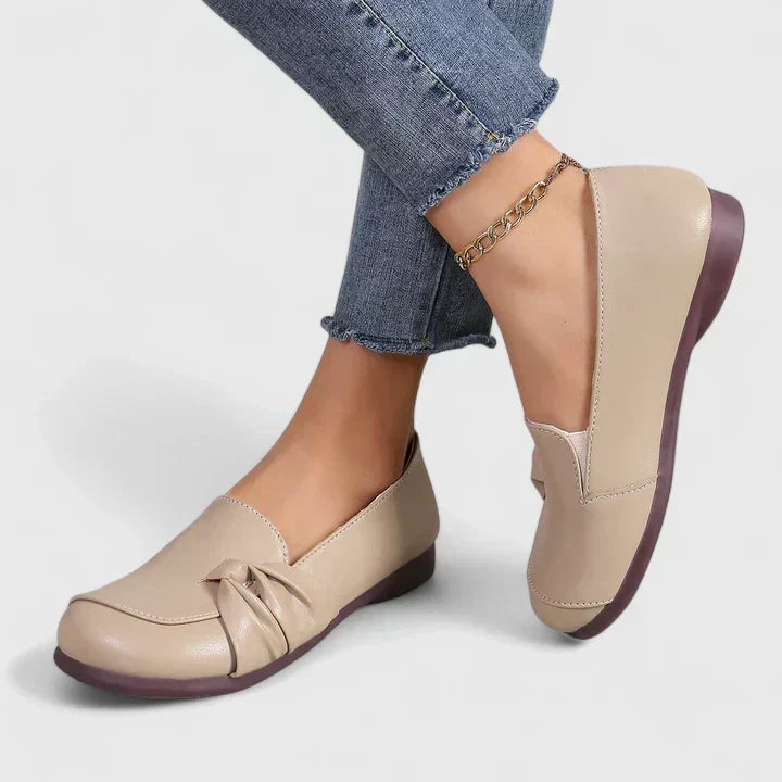 Lillian slip-on flat shoes in beige, worn angled view showing flat sole