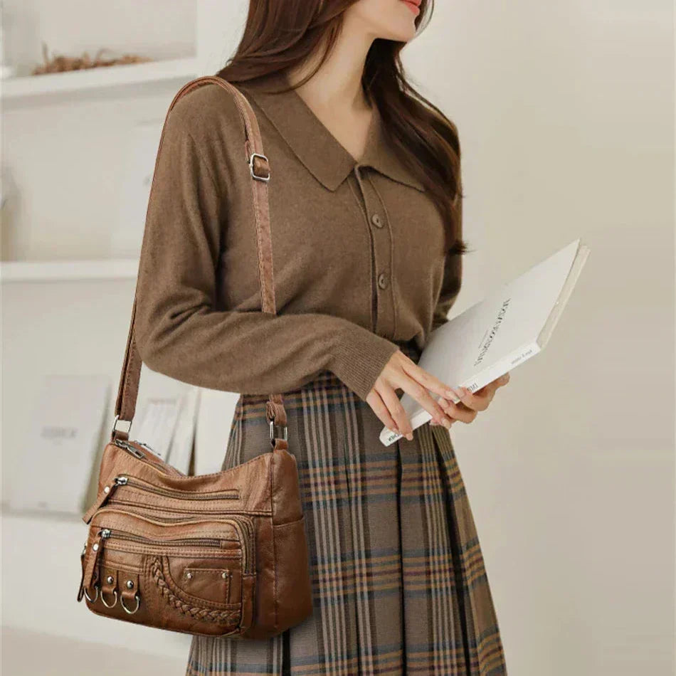 Olivia shoulder bag in brown worn over the shoulder by a model