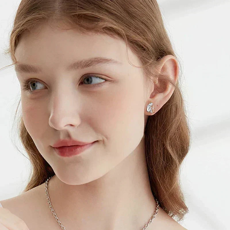 Avelien cat icon earring worn on the ear, close-up side view