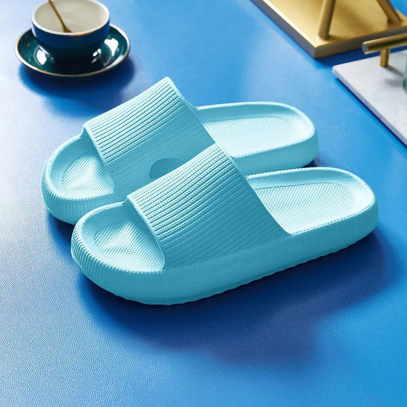 Light blue platform slide slippers on blue background, angled view