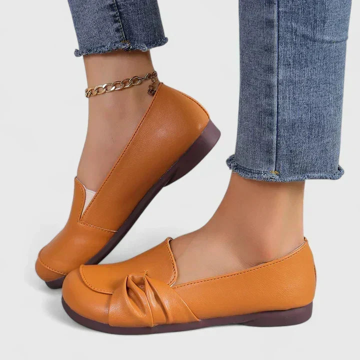 Lillian slip-on flat shoes in orange, worn side view with rounded toe