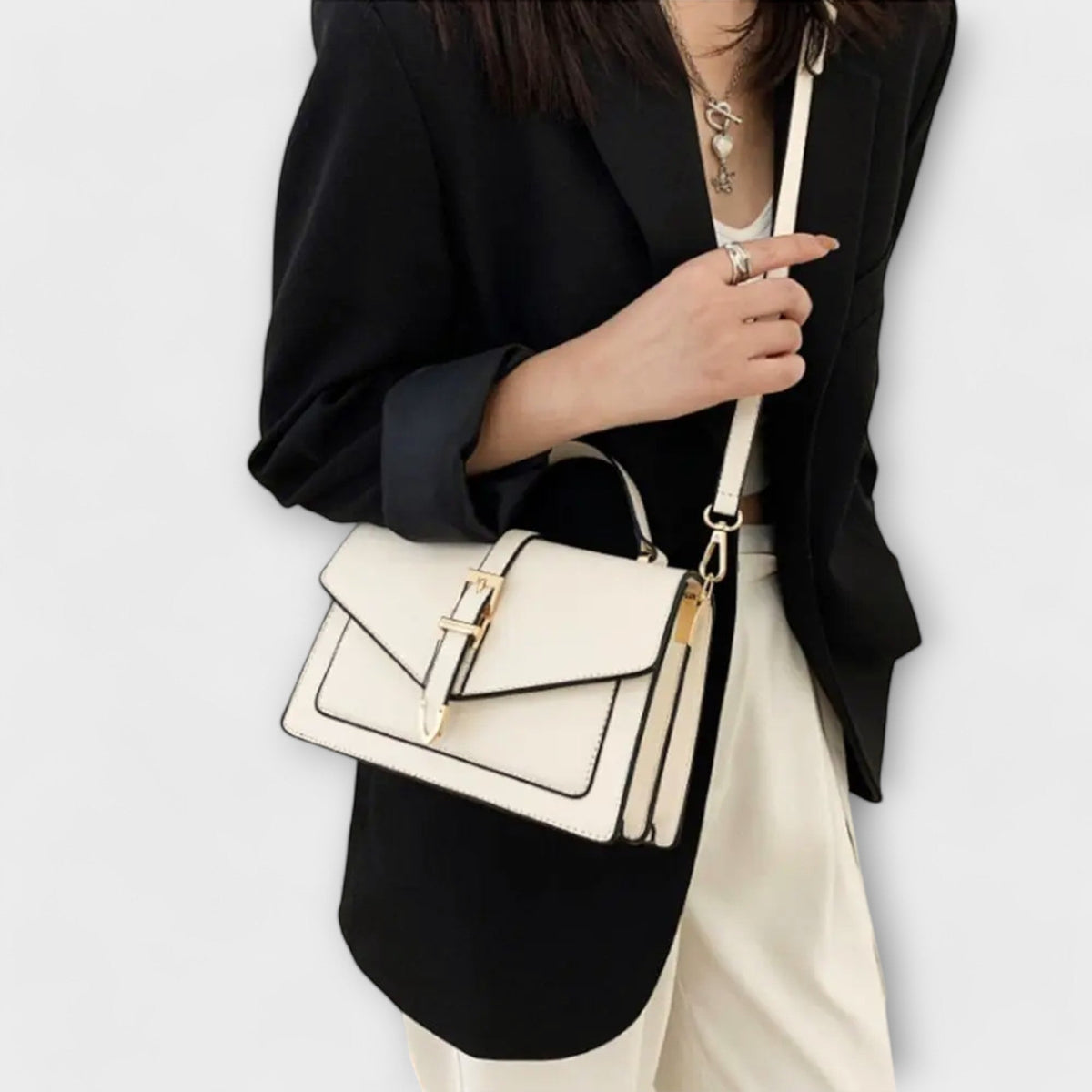 Olívia shoulder bag in white worn crossbody with black blazer