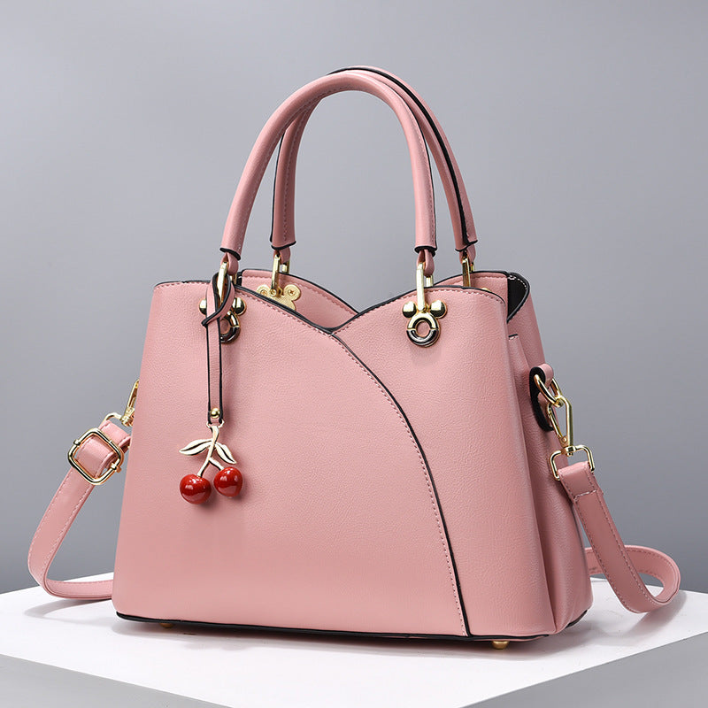 Avyra cherry tote bag in pink, front view with cherry charm