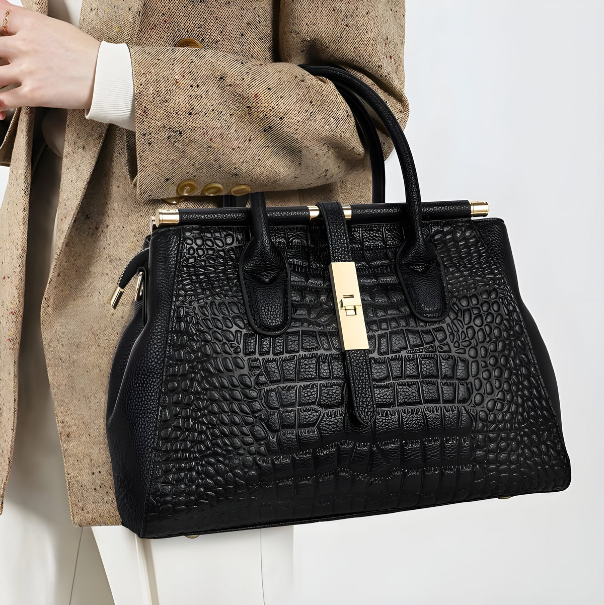 Aurelia croc handbag in black held against a beige blazer