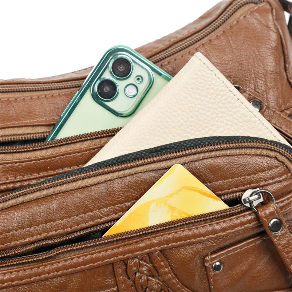 Close-up of Olivia bag zipped pockets holding a phone and purse
