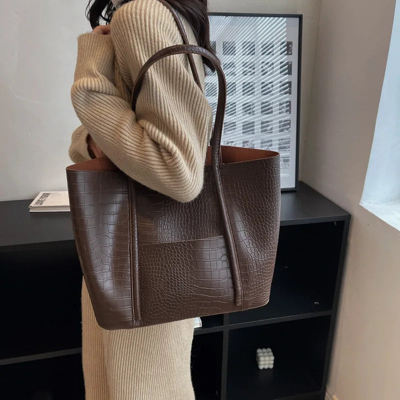 Sylvette croc shoulder bag in coffee, carried over the shoulder