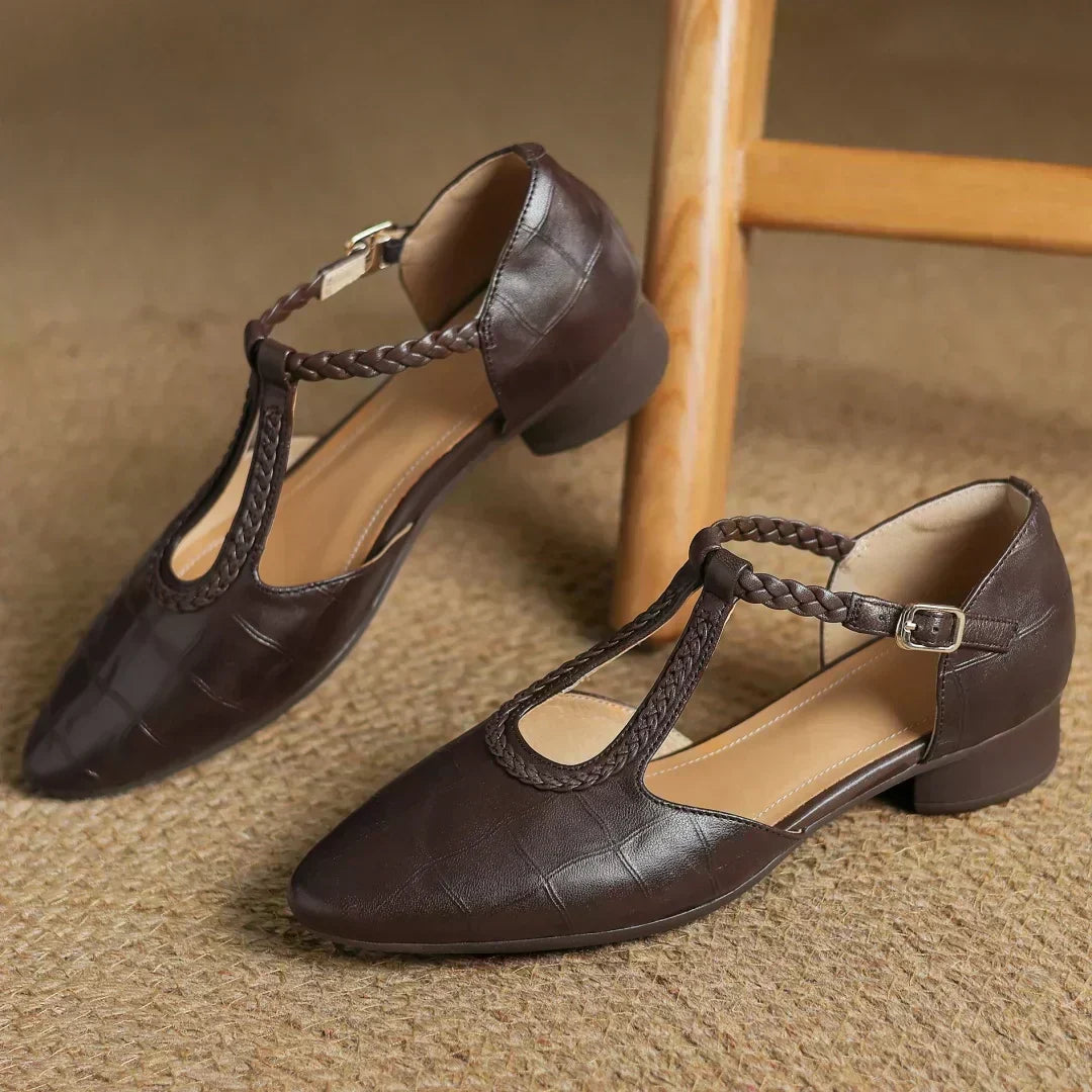 Evelyn classic Mary Janes in brown, pair resting beside a wooden chair