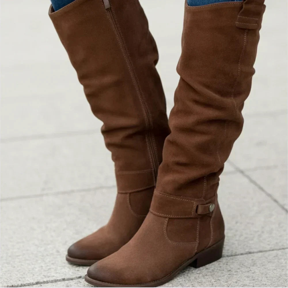Novalyn tall boots in brown, worn with jeans, side view