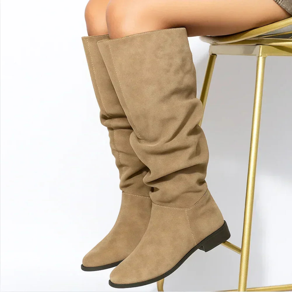 Roselia knee-high suede boots in beige worn by a seated model
