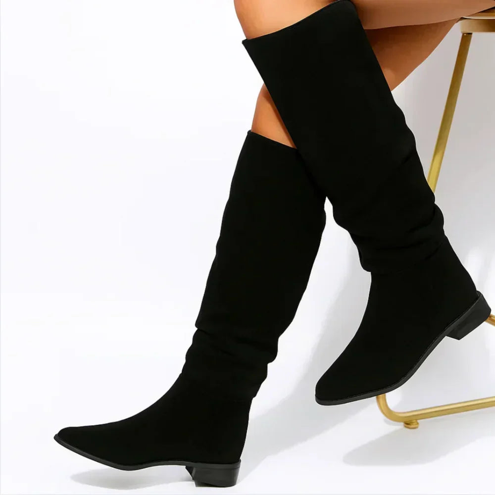 Roselia knee-high suede boots in black worn by a seated model