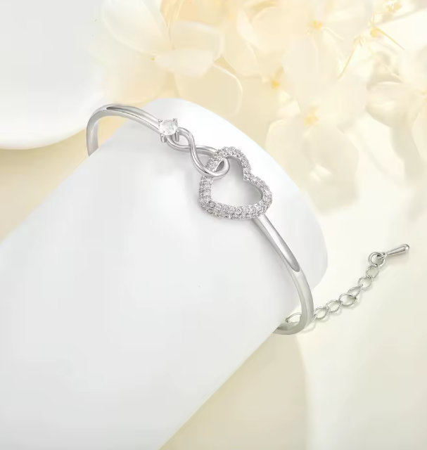 Endless Love heart bracelet in silver, styled with pale flowers