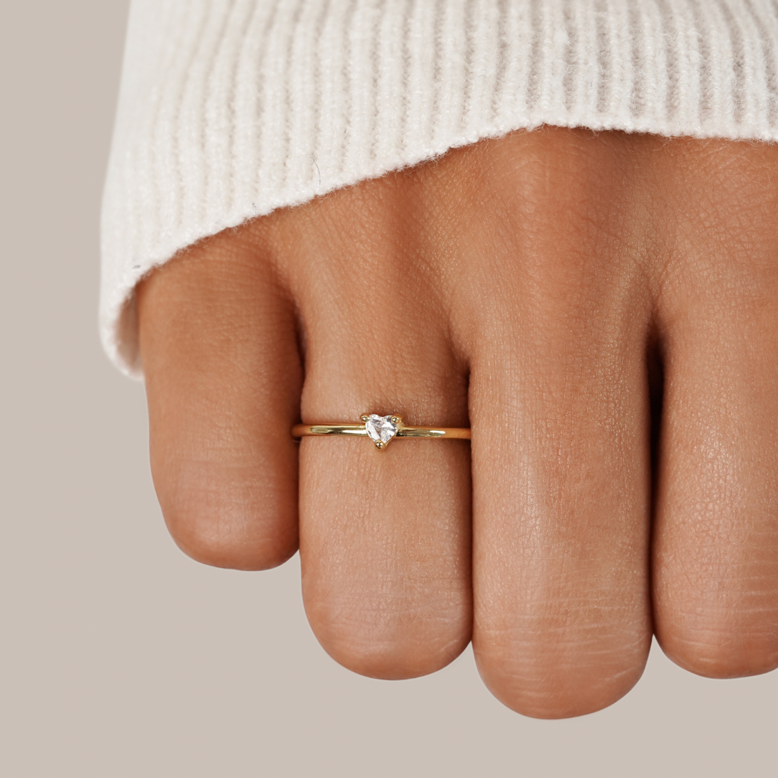 Leonie gold ring in gold worn on a model's finger, close-up view