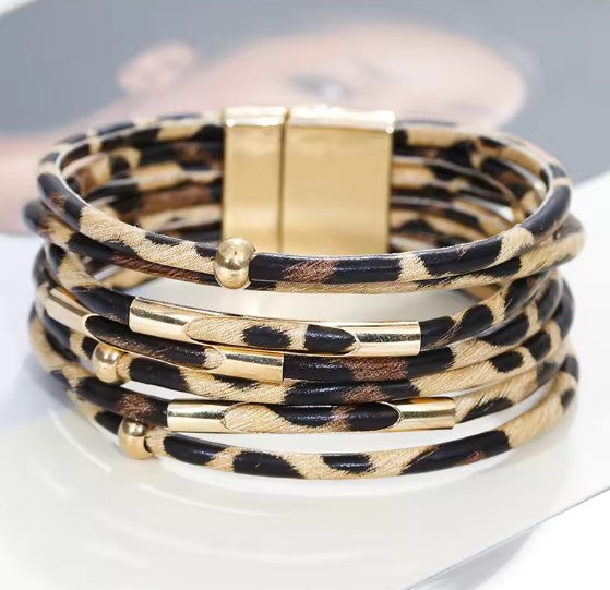 Layered wrap bracelet in leopard print with gold-tone bars and magnetic clasp, close-up view