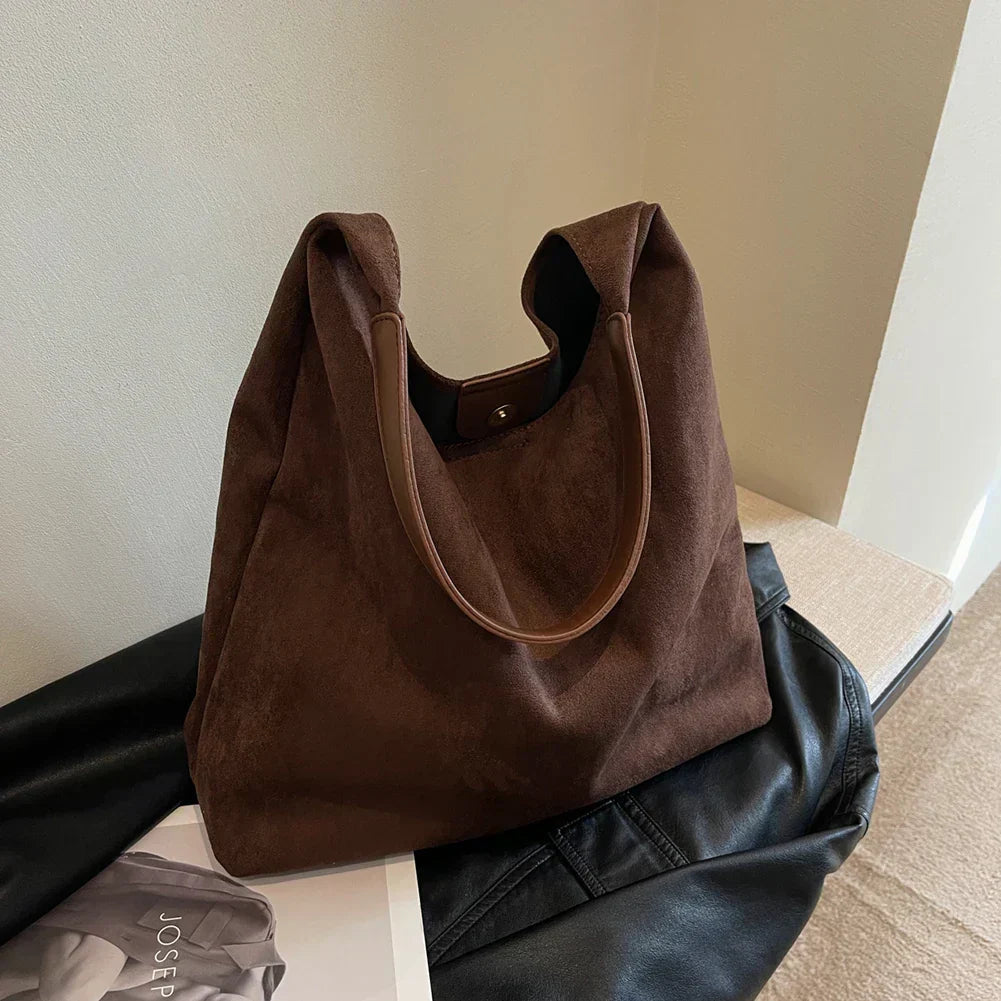 Ottilie shoulder bag in dark brown suede, styled indoors