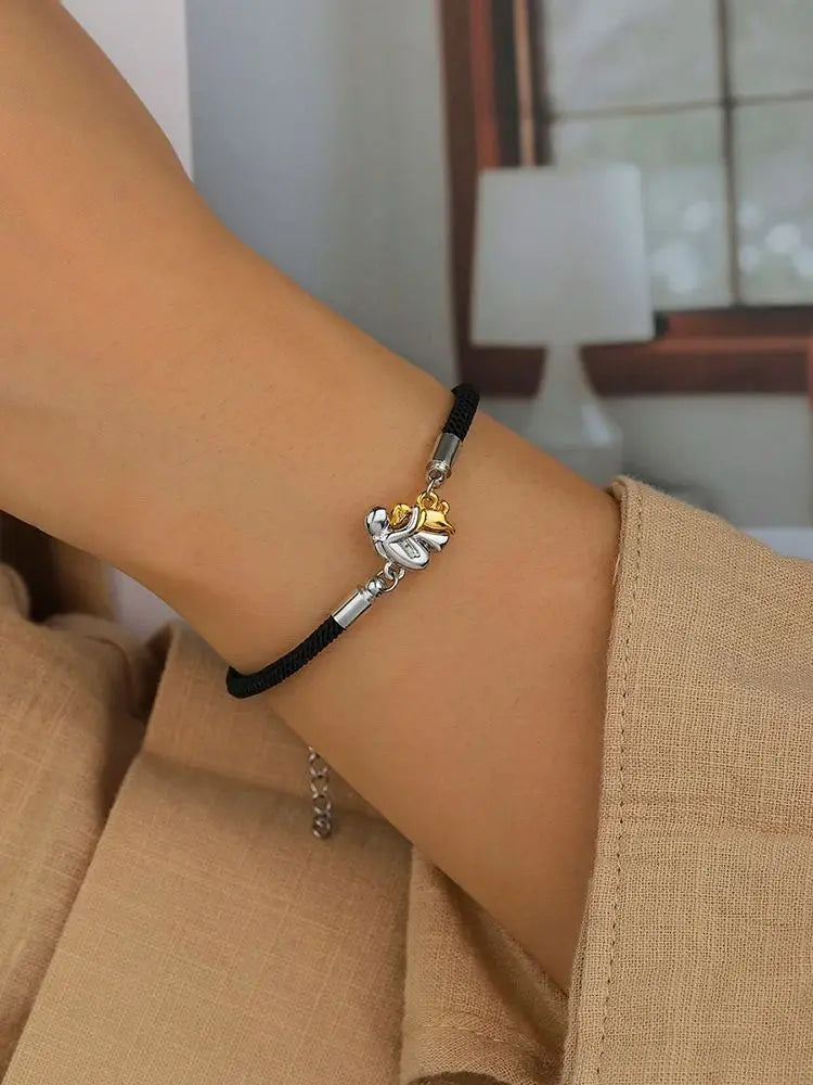 Woman and dog friendship bracelet in black cord with silver charm, worn on wrist