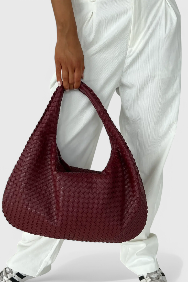 Tilly knitted shoulder bag in red wine, carried in the hand