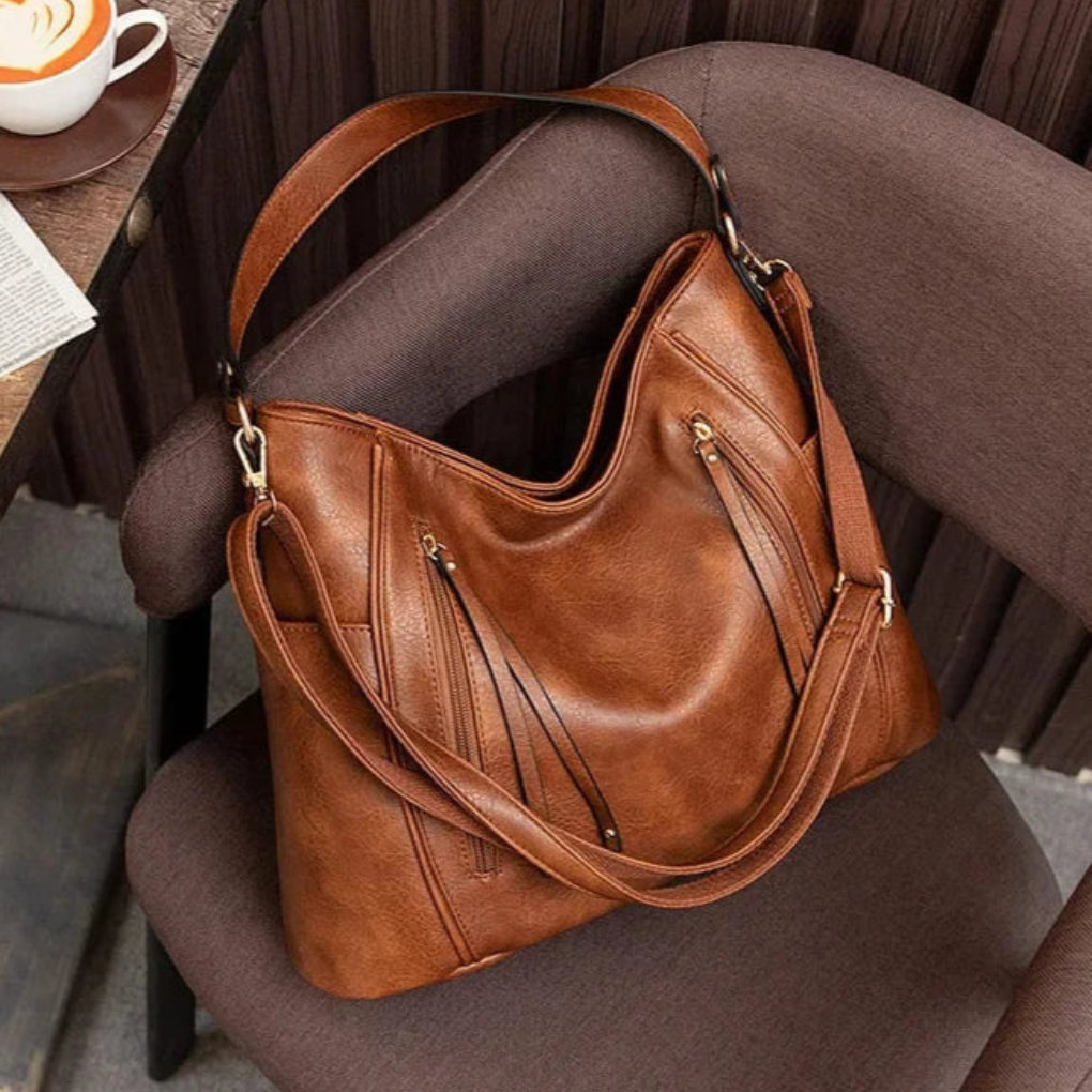Calista luxe shoulder bag in brown, resting on a chair