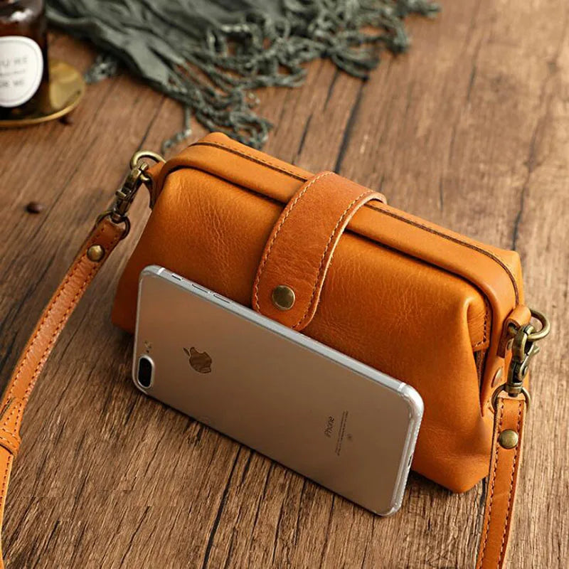Cressida mini crossbody bag in brown shown beside a phone