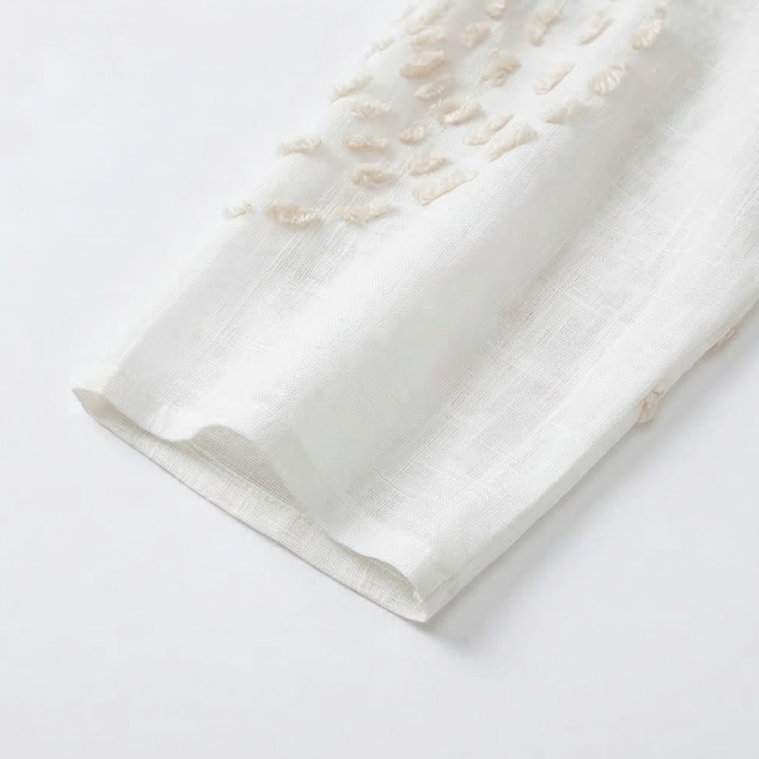 White embroidered dress, close-up of three-quarter sleeve hem