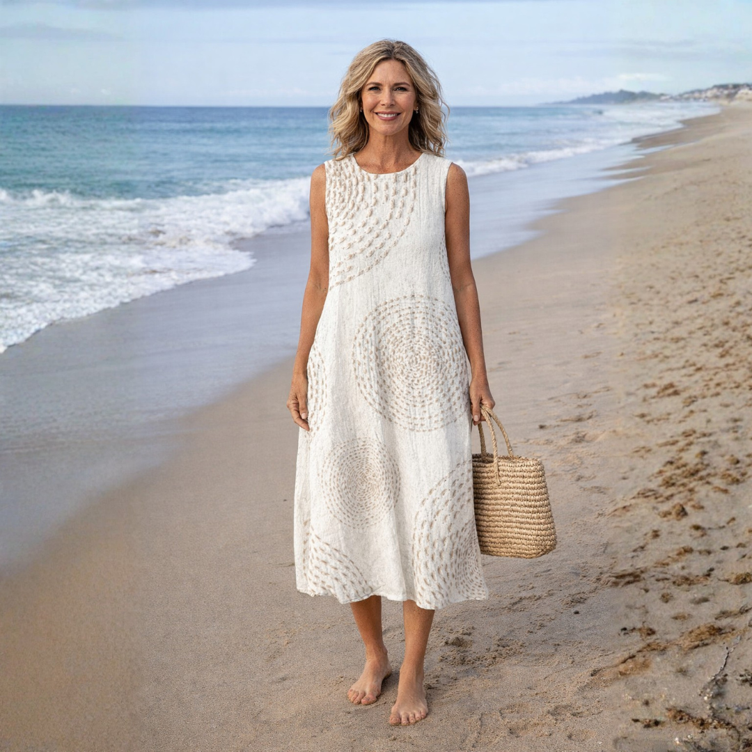 Luna sleeveless midi dress in beige, full-length view on the beach