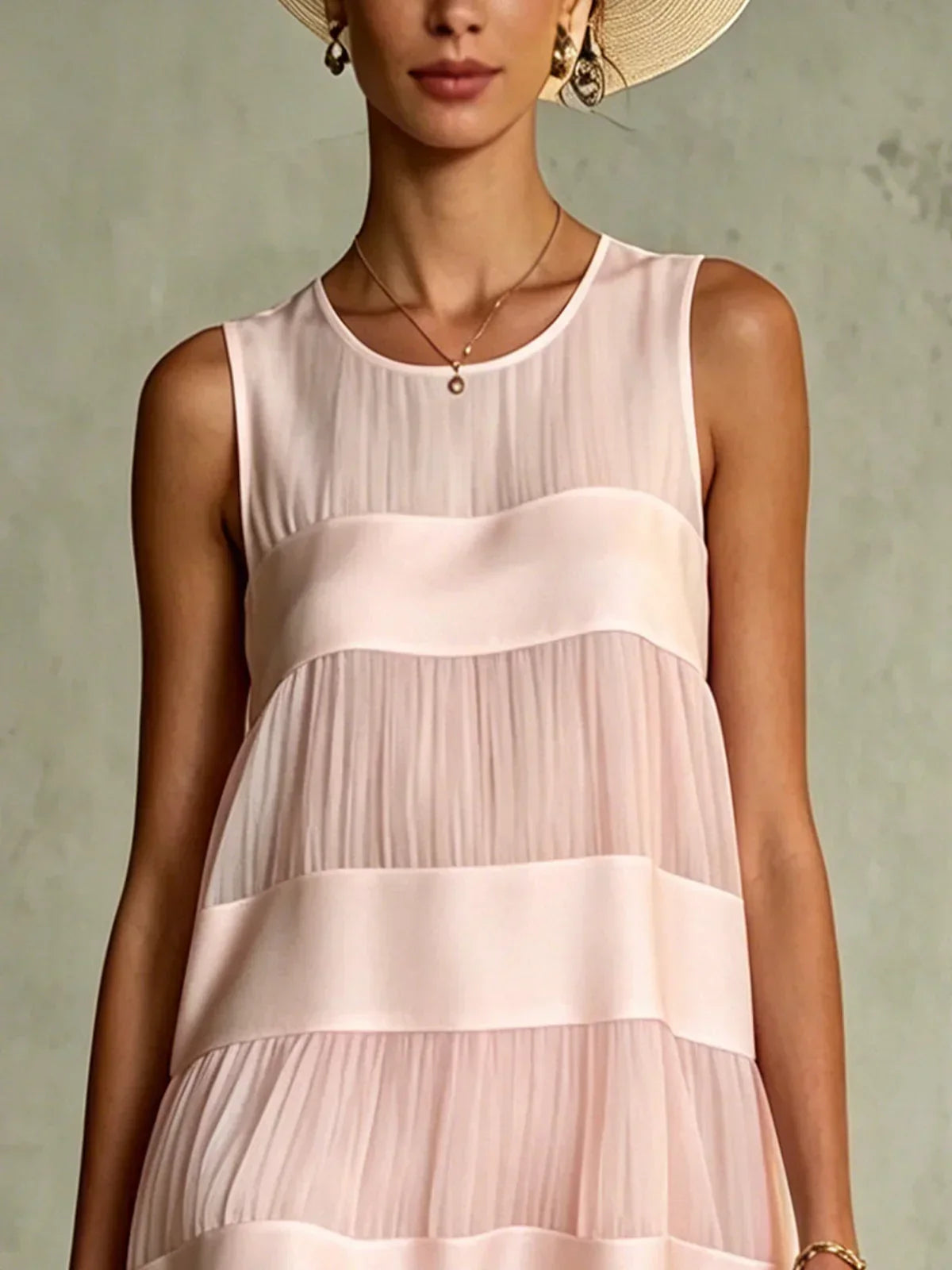 Close-up of round sleeveless neckline and satin panels on pink mini dress