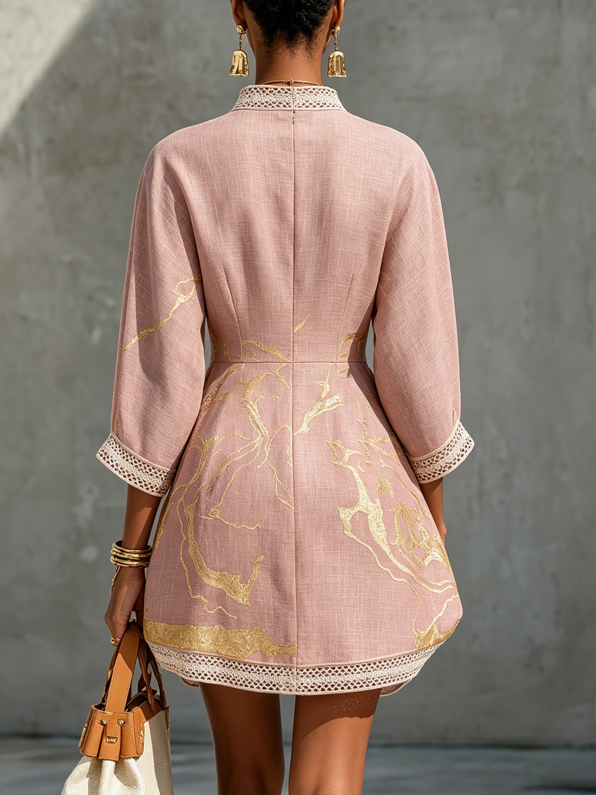 Ninon pink mini dress, back view showing gold marbled print and lace hem