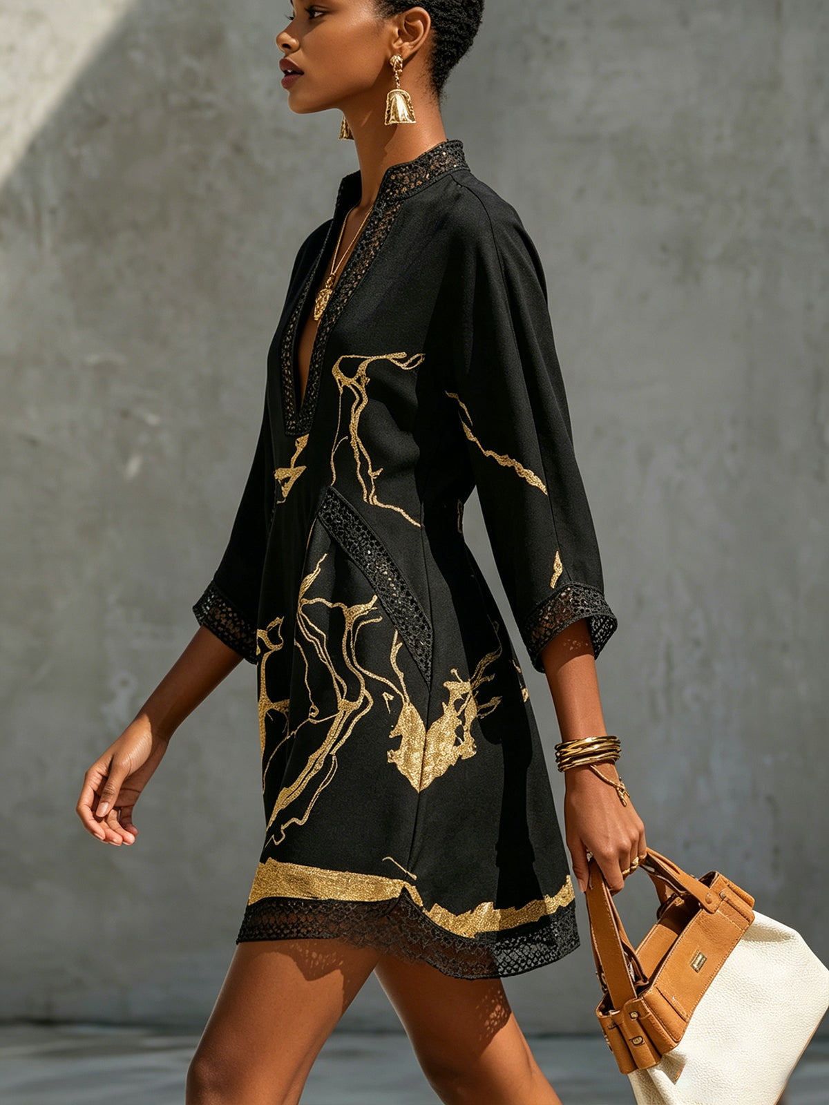 Léonie black mini dress with gold details, side view walking