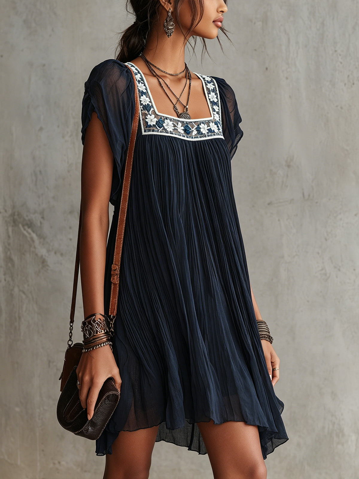 Apolline pleated mini dress in navy, three-quarter view on model