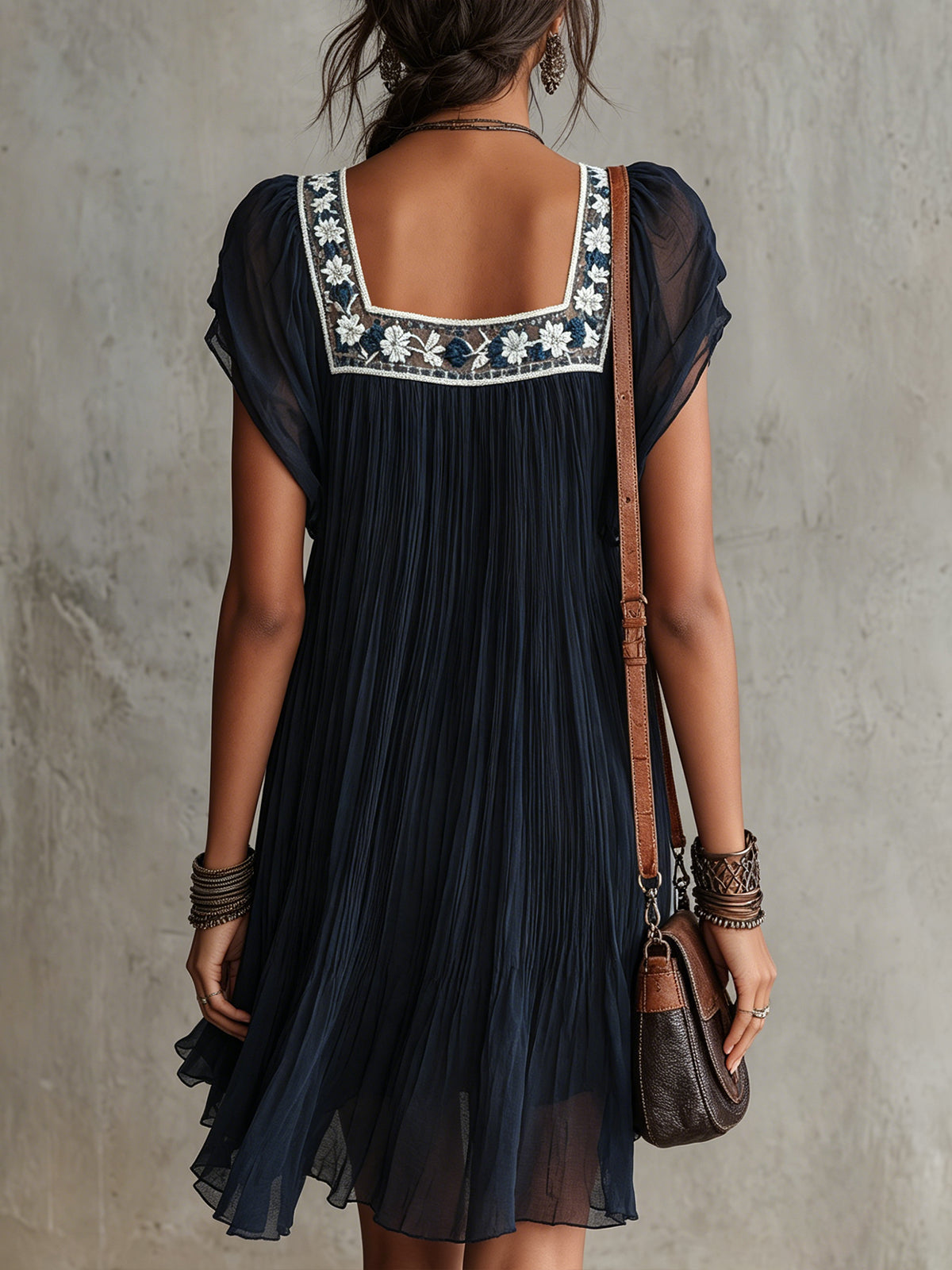 Apolline pleated mini dress in navy, back view showing embroidered yoke