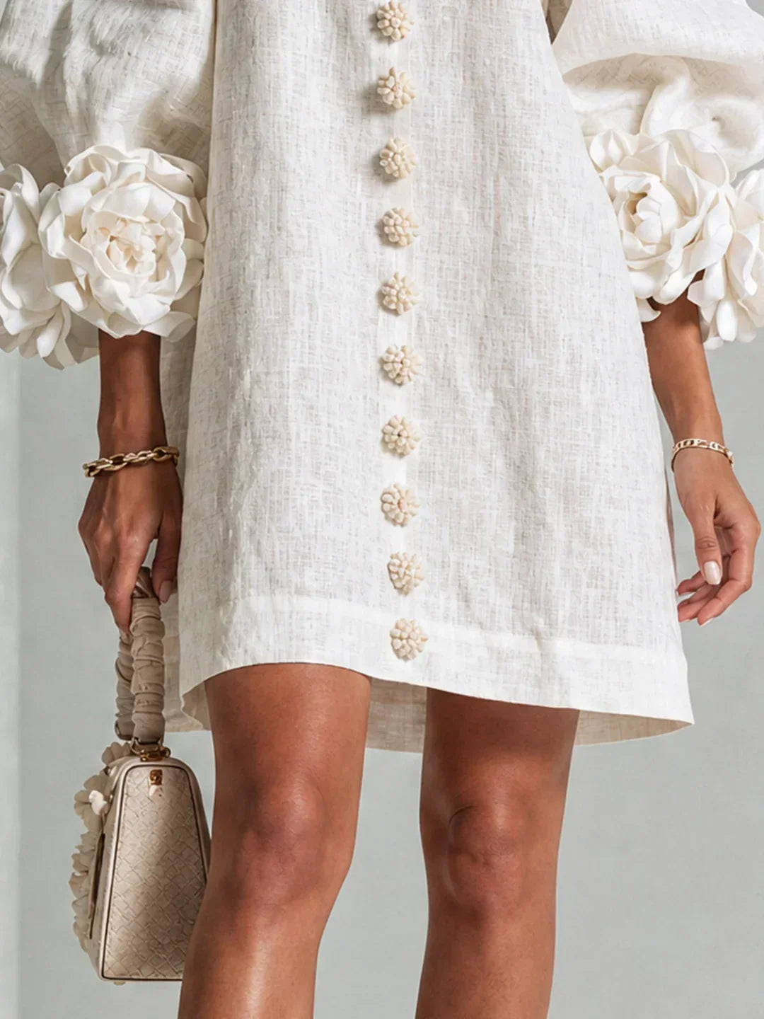 Elvira mini dress in white, close-up of hem and rosette cuffs