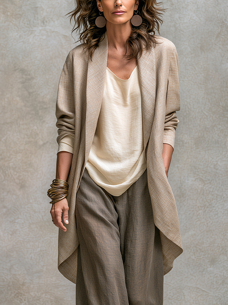 Close view of the draped beige jacket and cream top of the three-piece suit