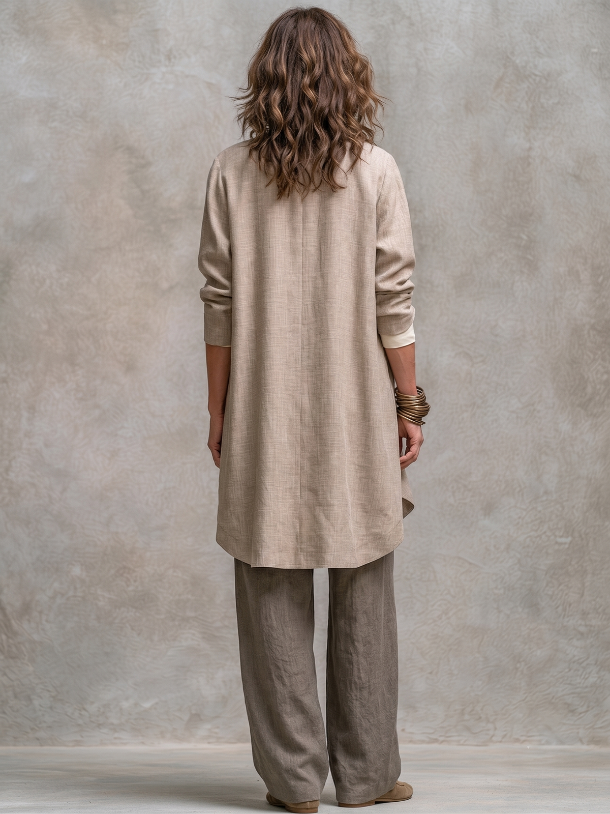 Beige-grey three-piece suit seen from the back, longline jacket and trousers