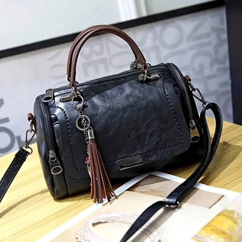 Eliana leather shoulder bag in black, front view with shoulder strap