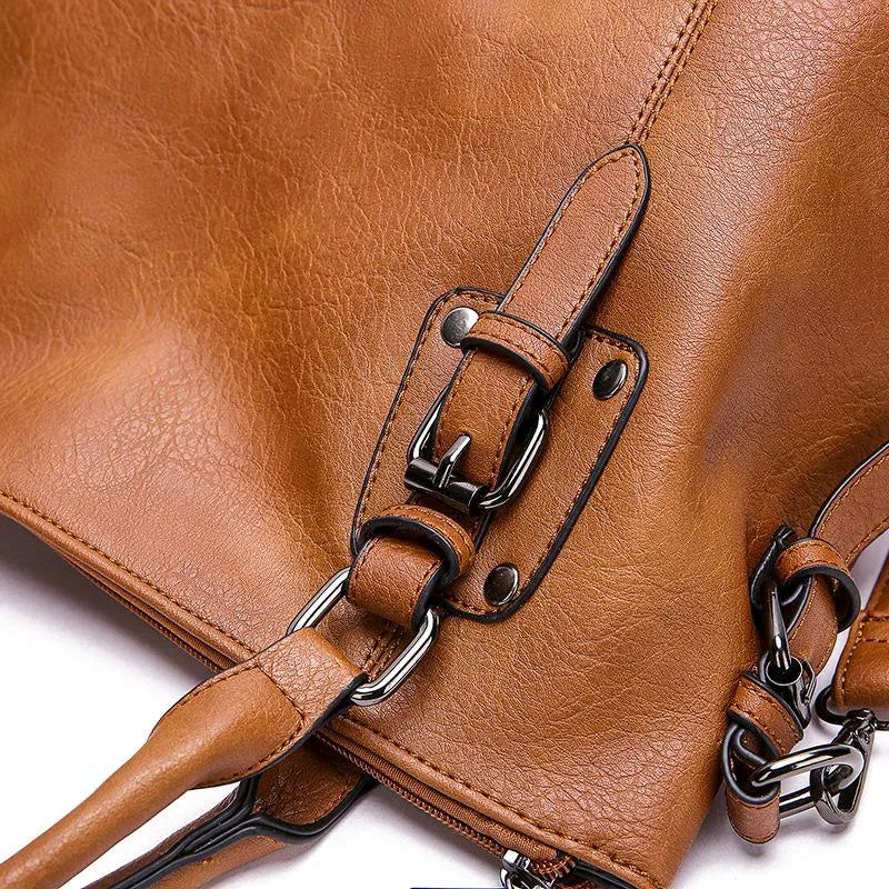Evadne shoulder bag close-up of buckled leather strap and stitching