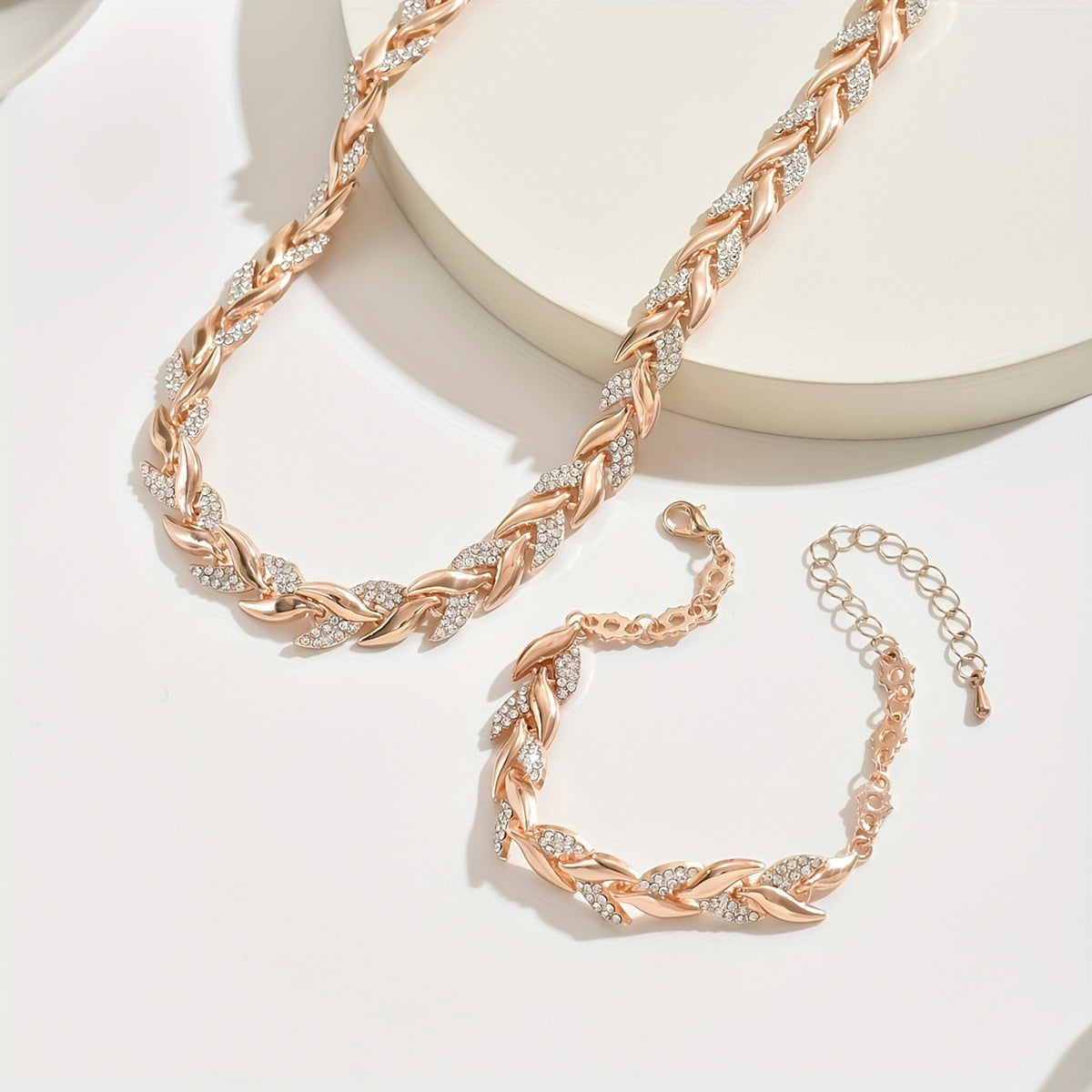 Rose gold fish tail necklace and bracelet on a white background
