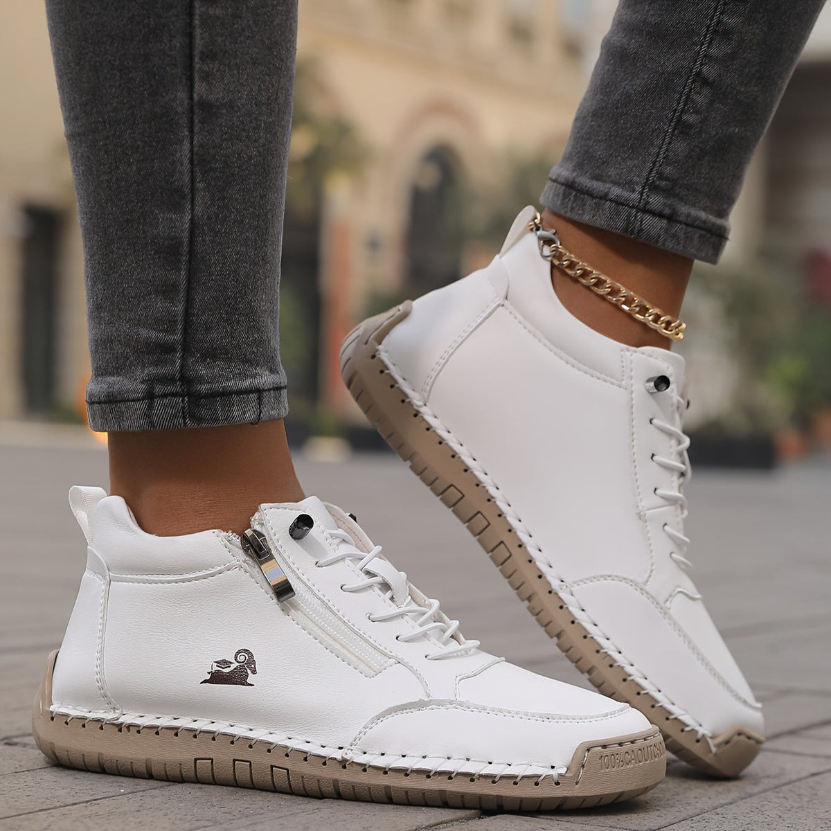 Mila trainers in white worn with jeans, side zip close-up