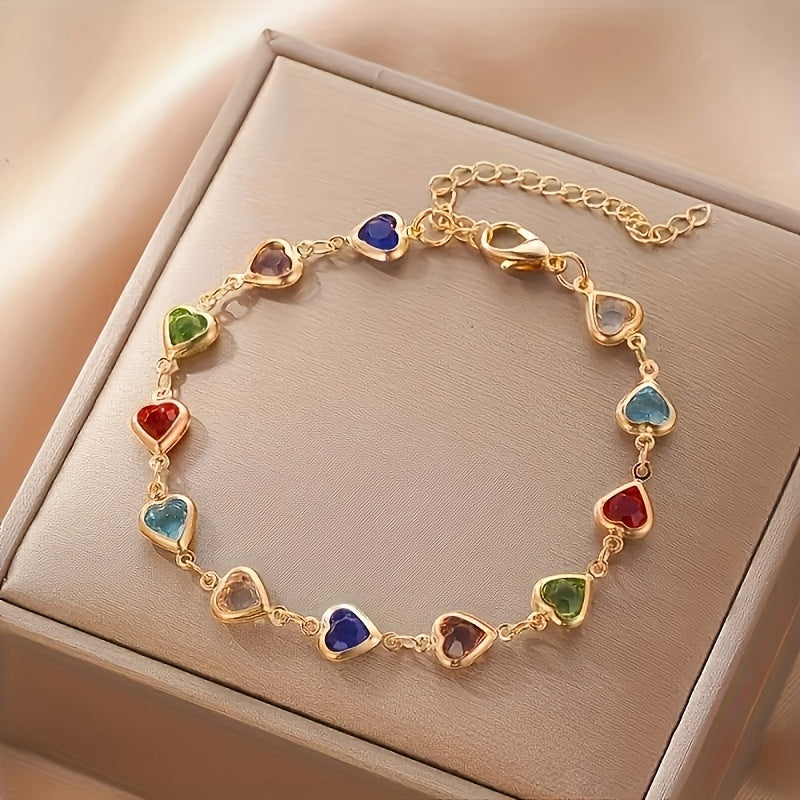 Heart-shaped gold bracelet with multicoloured stones, close-up on gift box
