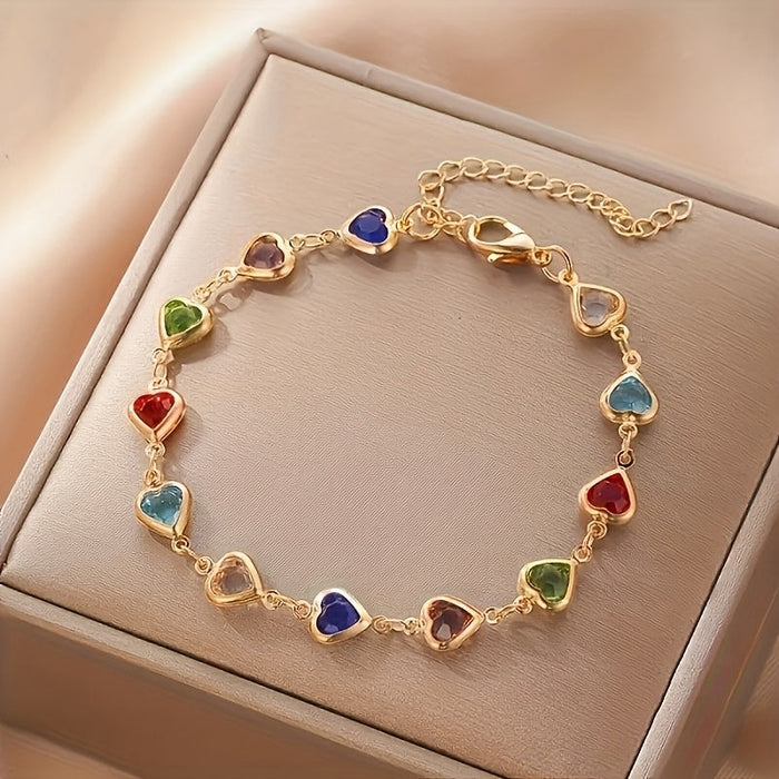 Heart-shaped gold bracelet with multicoloured stones, close-up on gift box