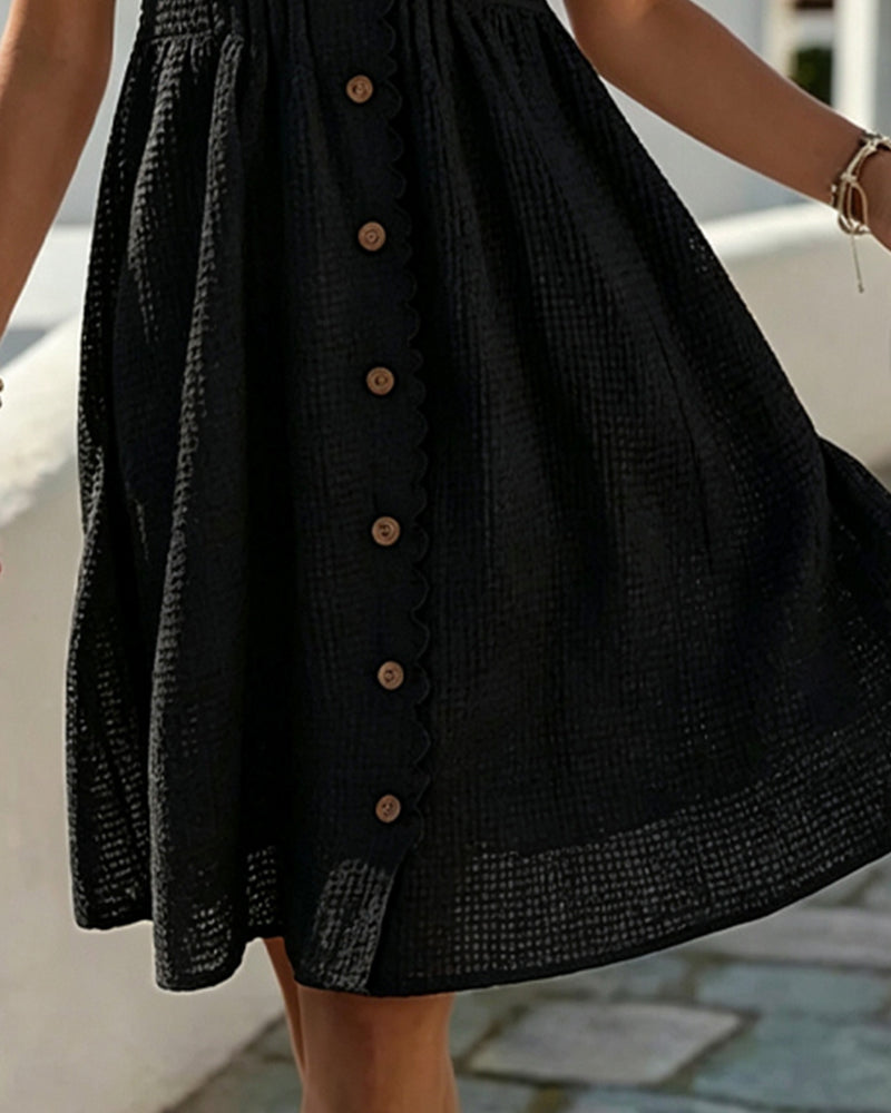 Close-up of black Deneke dress showing front buttons and flared skirt