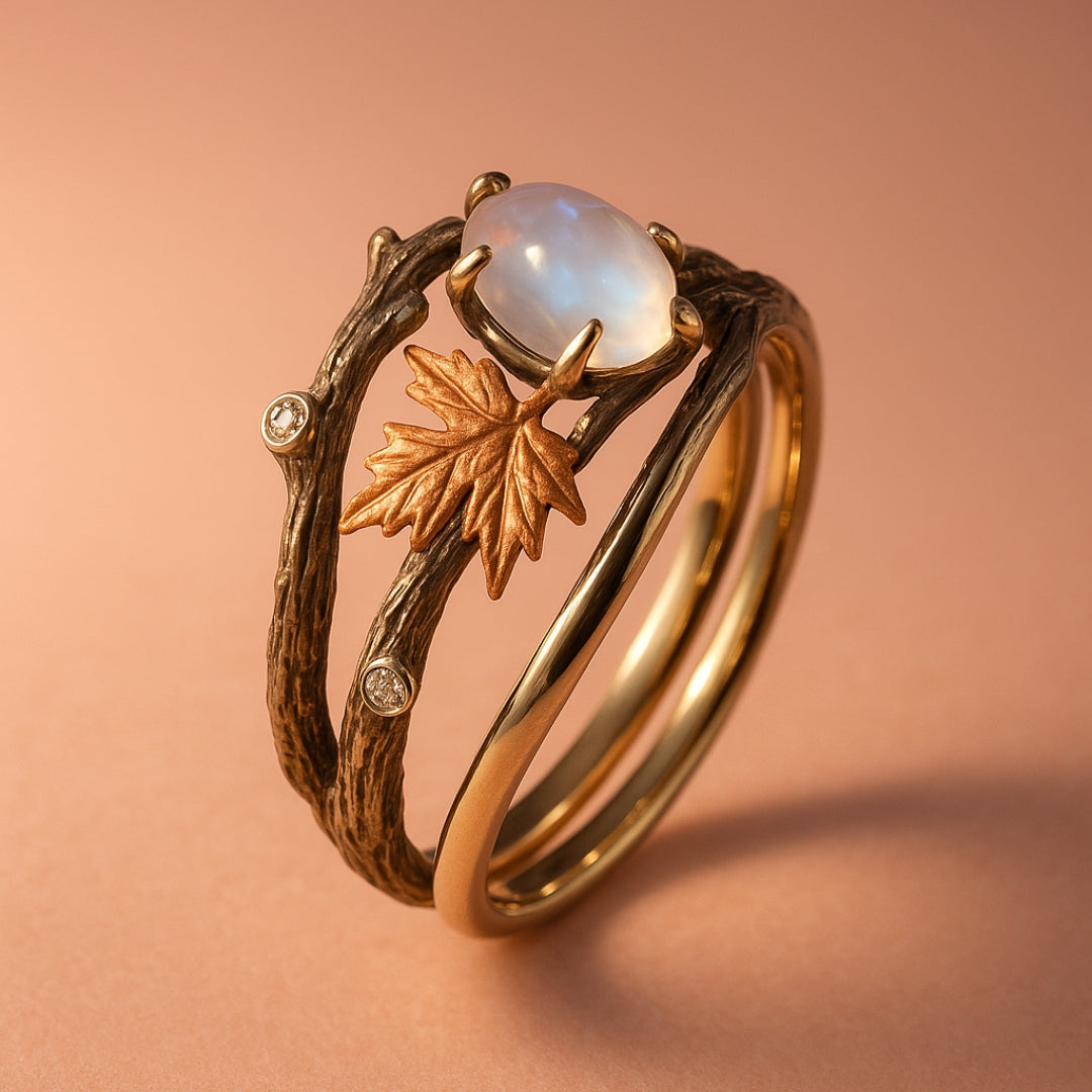 Moonstone ring with gold maple leaf and stone accents, close-up