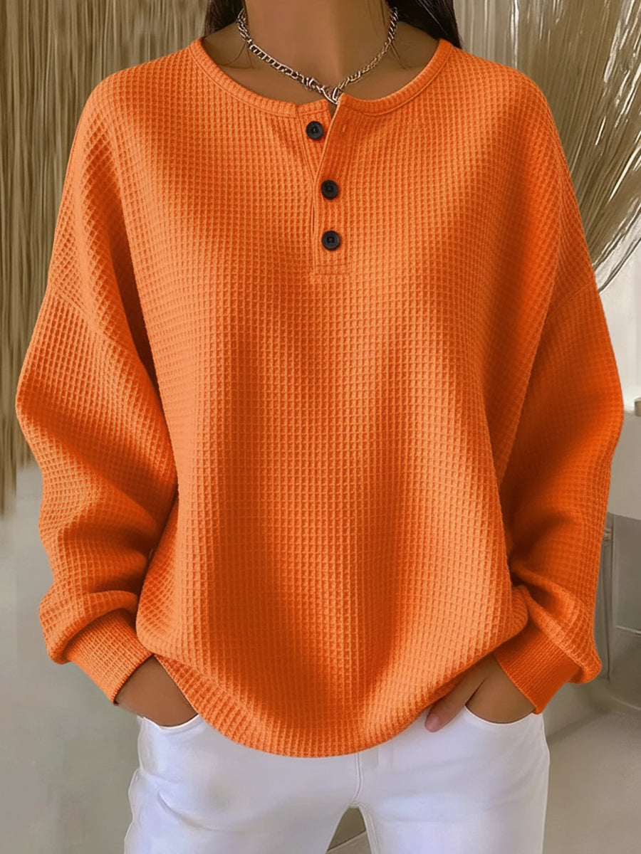 Milagros textured Henley sweatshirt in orange, front view worn with white jeans