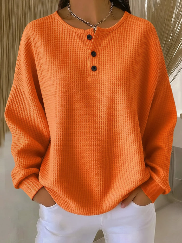 Milagros textured Henley sweatshirt in orange, front view worn with white jeans