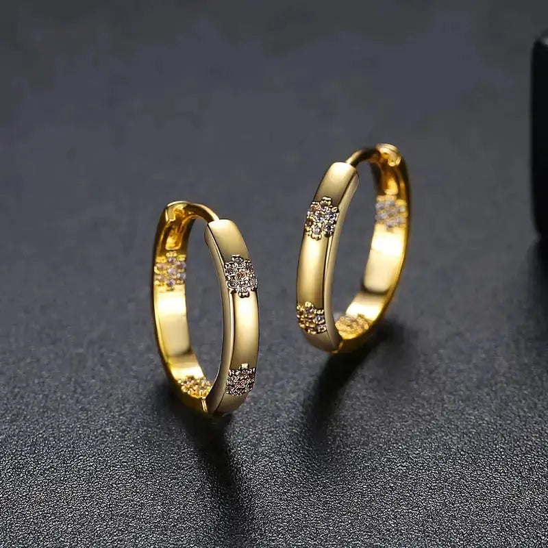 Vintage golden flower hoop earrings with sparkling floral clusters, angled close-up view