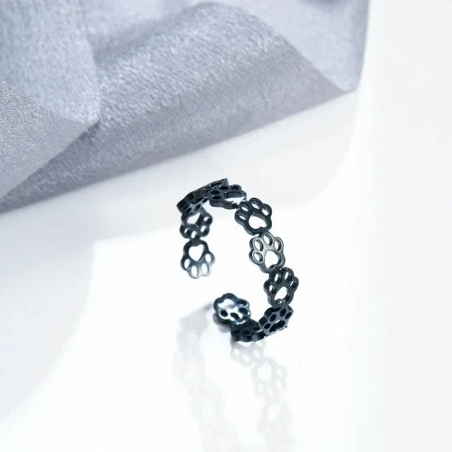Cat paw ring in black, side view on a white surface
