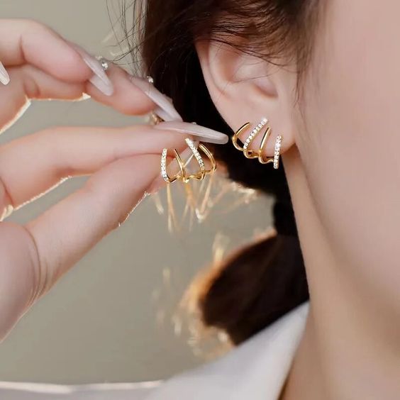 Zabby gold spiral ear cuff worn on the lobe, angled view
