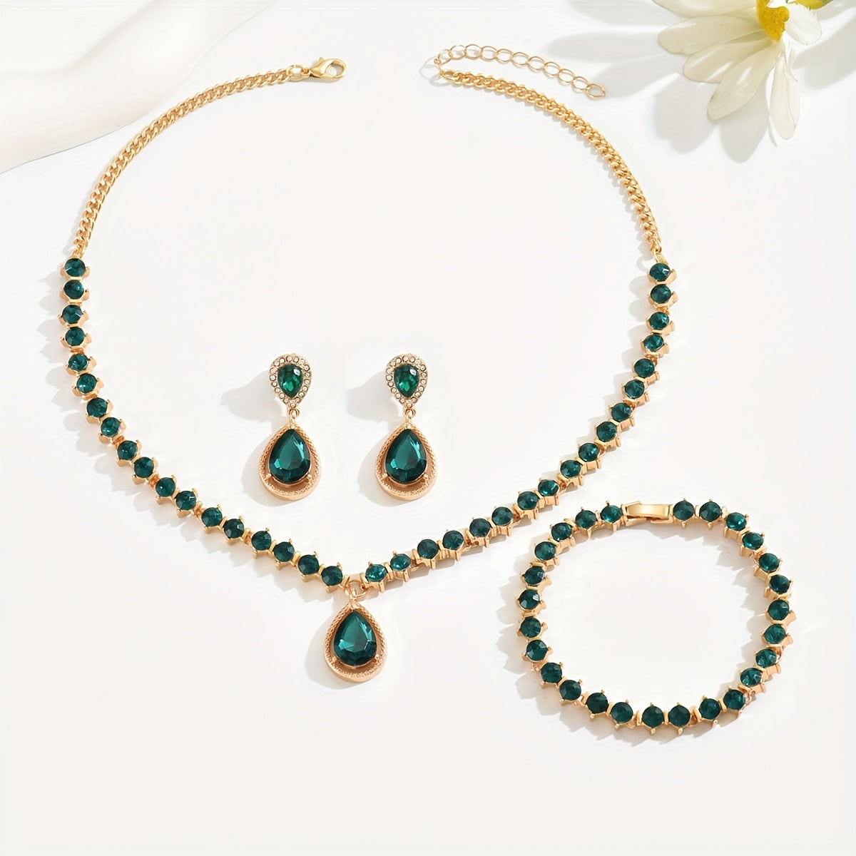 Gold and green crystal necklace, earrings and bracelet laid flat