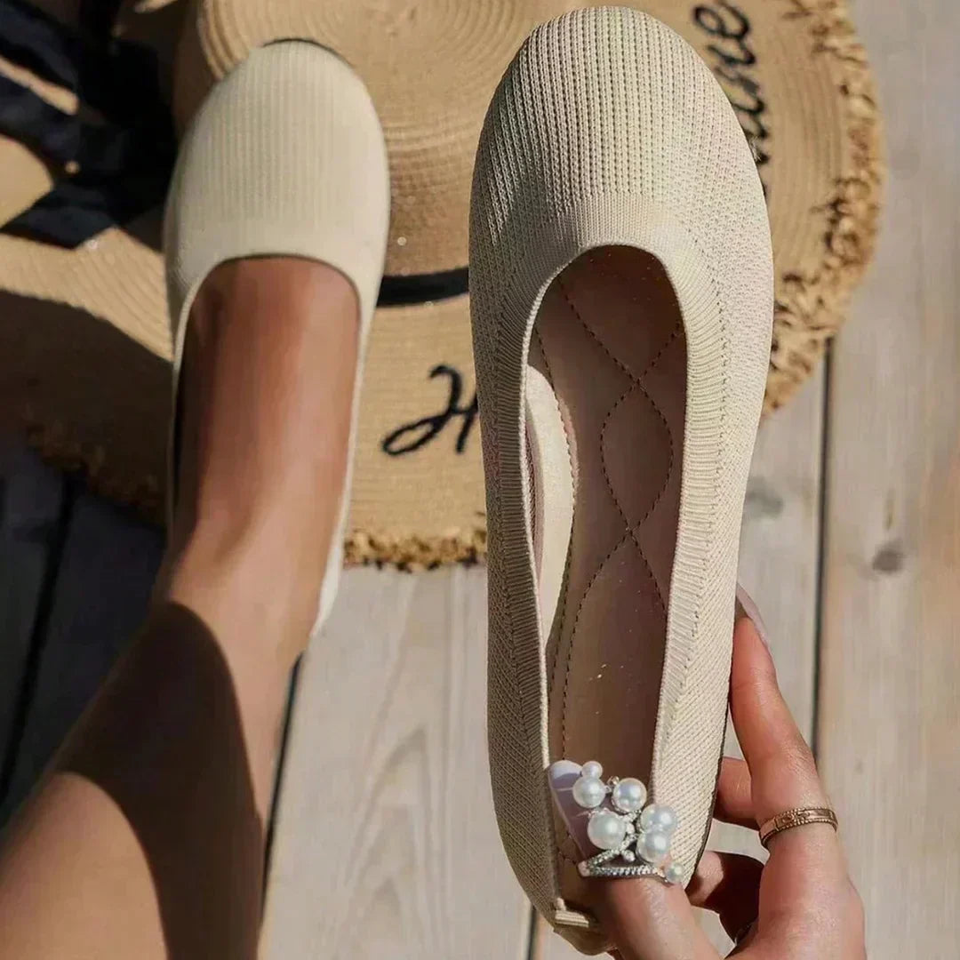 Anna slip-on shoes in beige, held to show inner footbed