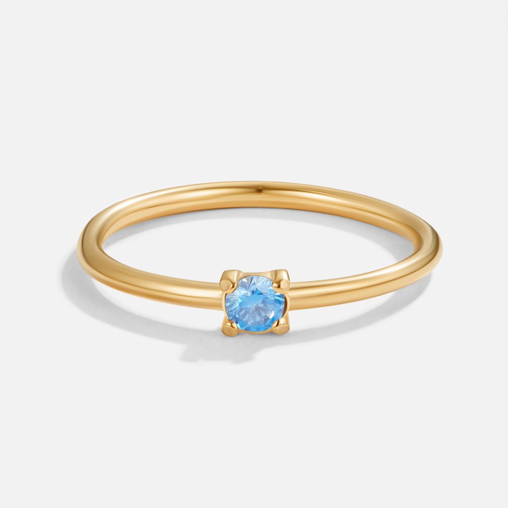 Gold birthstone ring with blue aquamarine stone, close front view